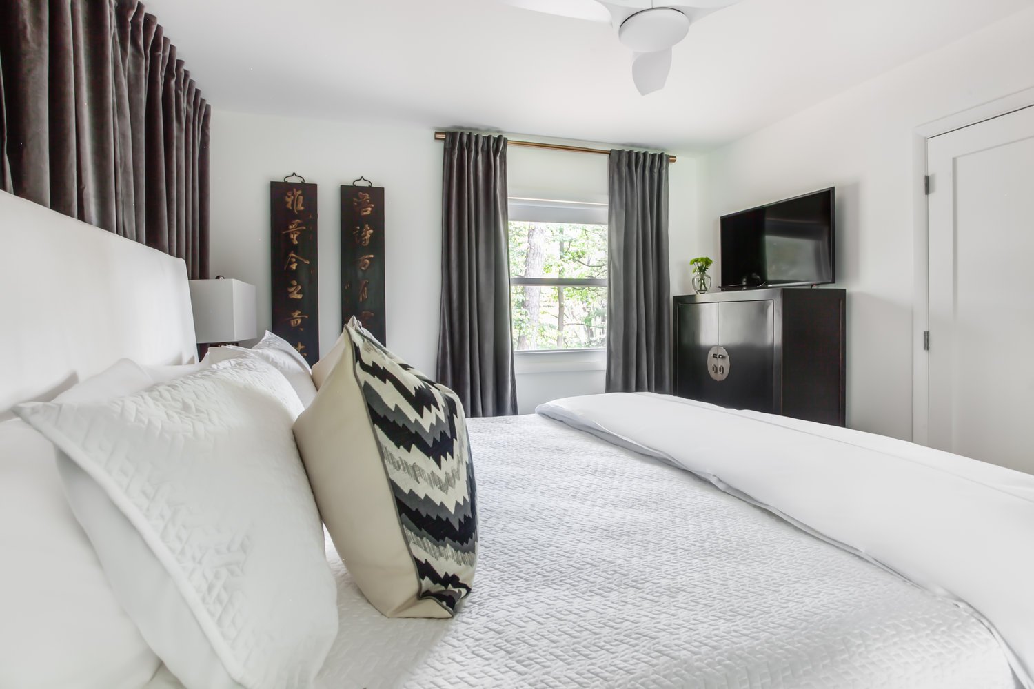 Bedroom with Large Bed, TV, and Dresser.