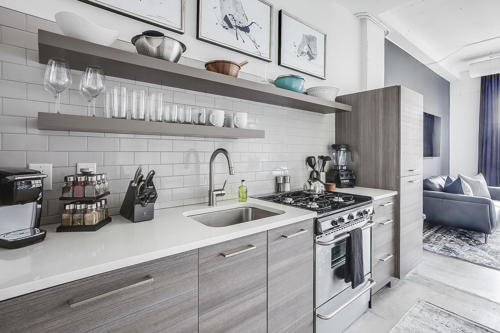 Kitchen with modern appliances and shelves full of bowls and cups.