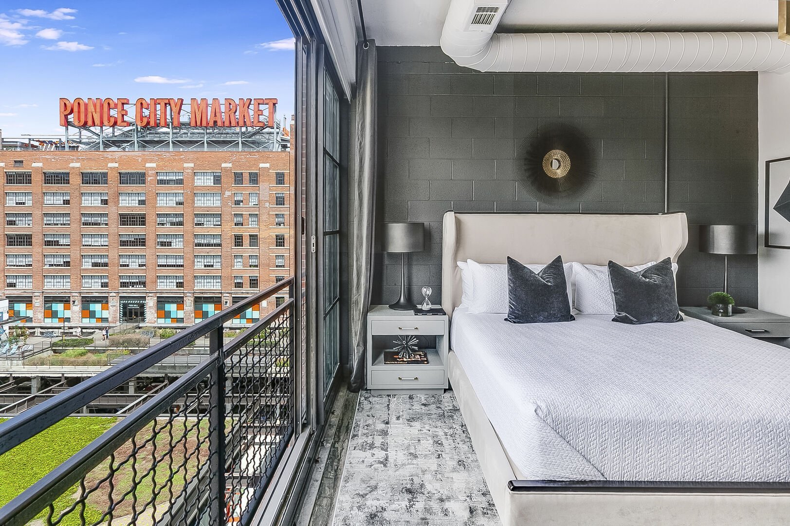 Sleeping area with a large bed and twin nightstands.