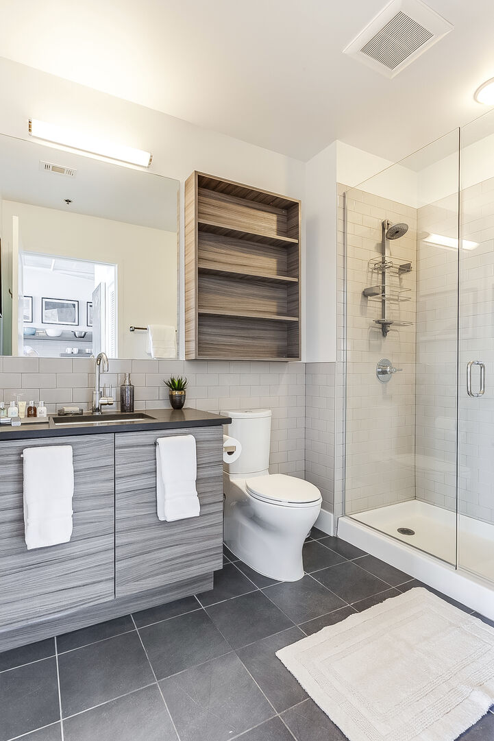 Bathroom of this Ponce City Flat with vanity sink, toilet, and walk-in shower.
