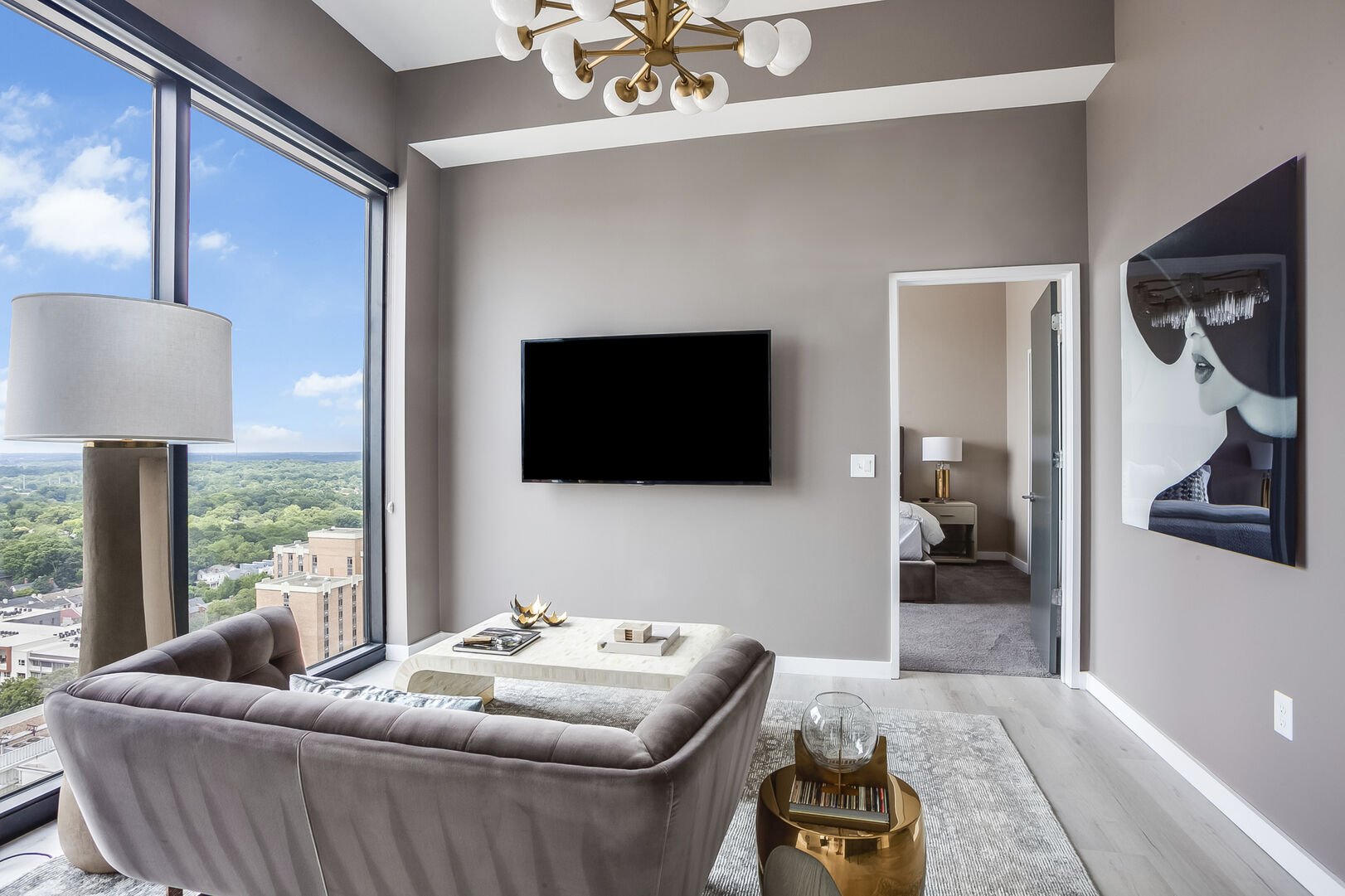 Living Area with Sofa, TV, and Large Window with City View