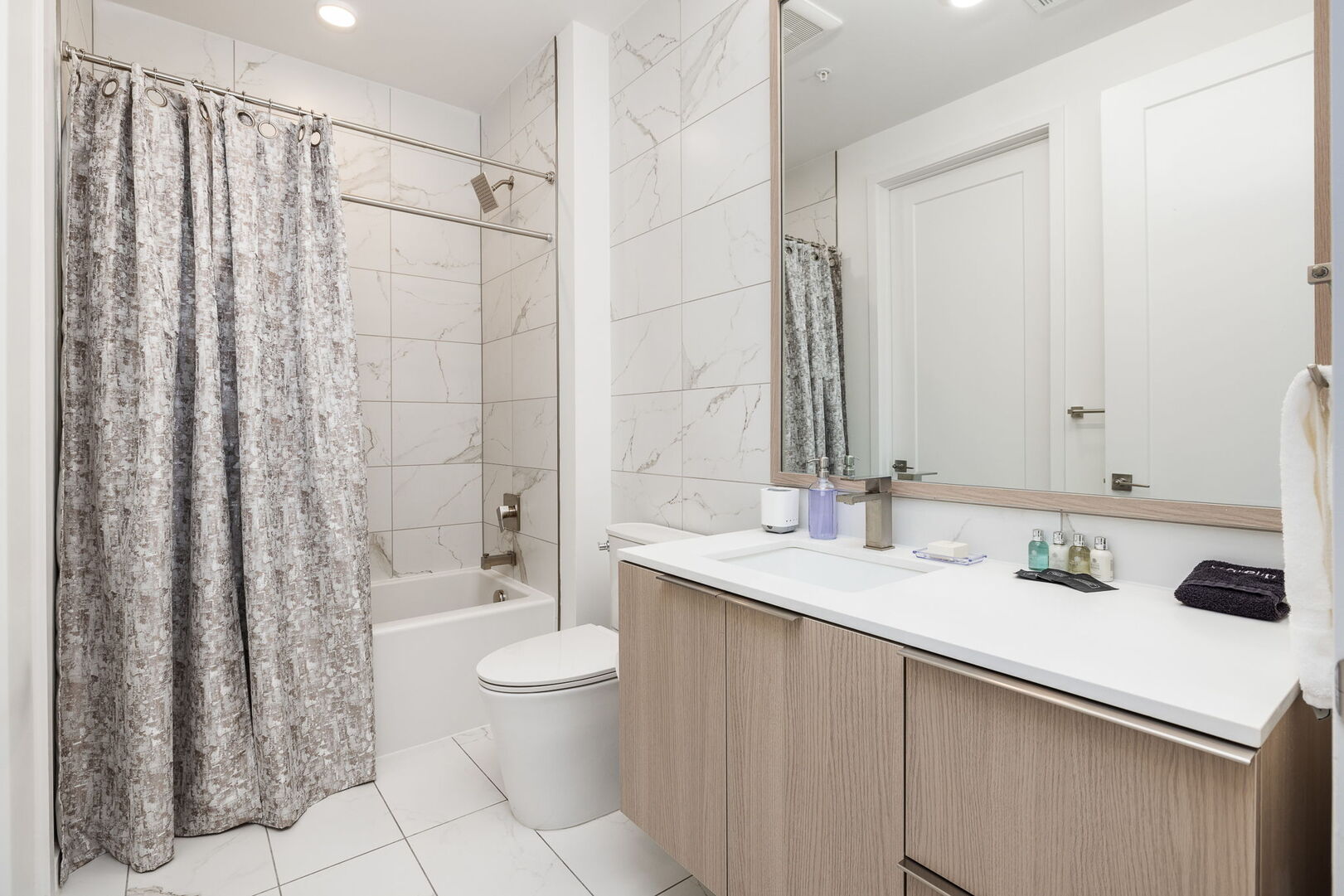 An en-suite bathroom featuring a single vanity and a spacious tub and shower.