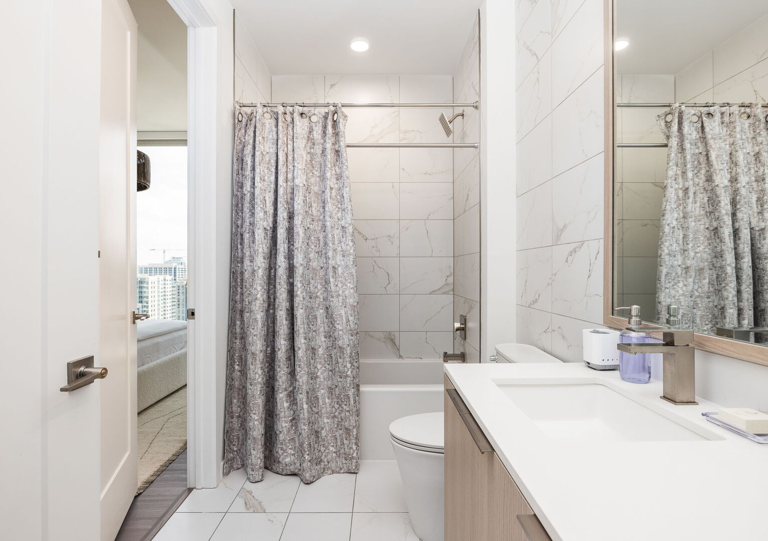 An en-suite bathroom featuring a single vanity and a spacious tub and shower.