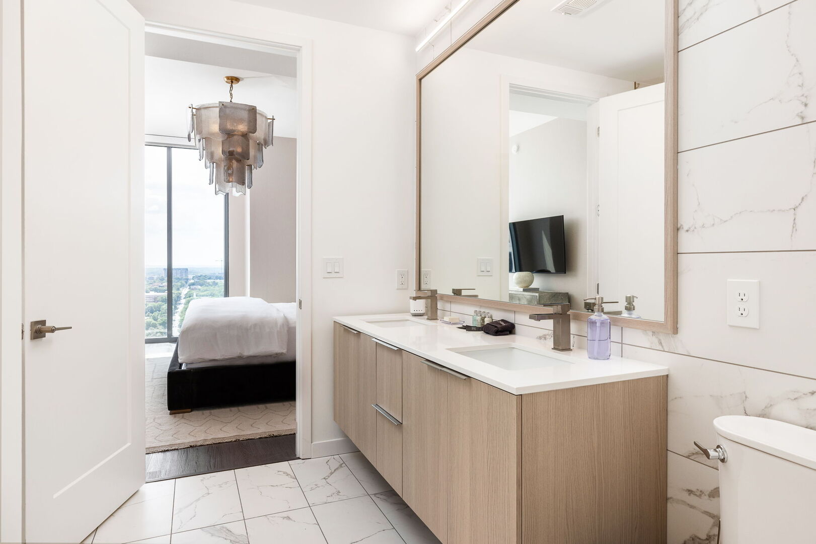 An en-suite bathroom featuring a double vanity and a spacious walk-in shower and closet