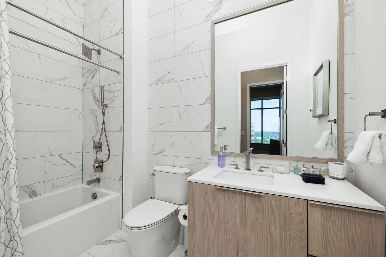 An en-suite bathroom featuring a single vanity and a spacious tub and shower.