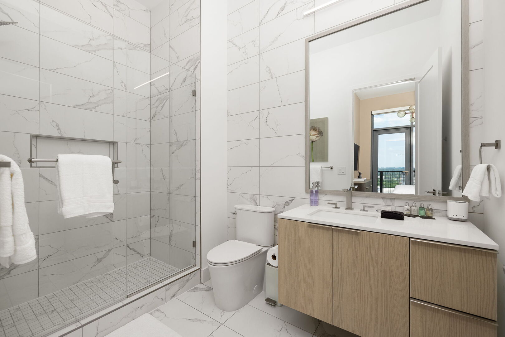 An en-suite bathroom featuring a  a single vanity and a walk-in shower