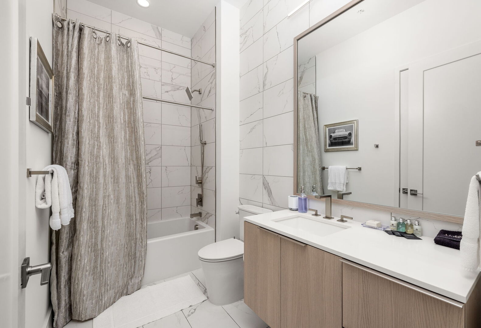 An en-suite bathroom featuring a single vanity and a spacious tub and shower.
