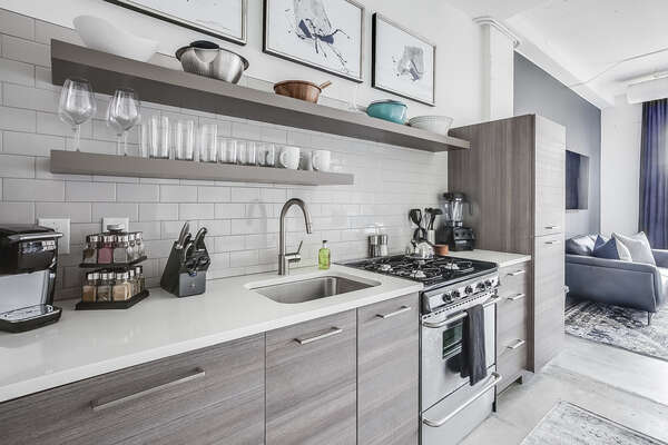 Kitchen with modern appliances and shelves full of bowls and cups.