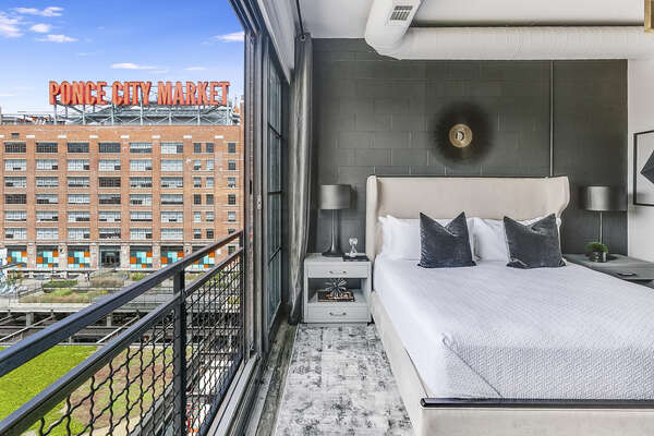 Sleeping area with a large bed and twin nightstands.