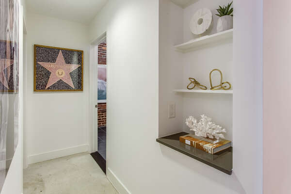 Hallway Includes Art and Space on Shelves.