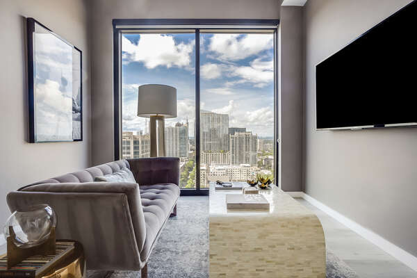 Living Area with Sofa, TV, and Large Window with City View