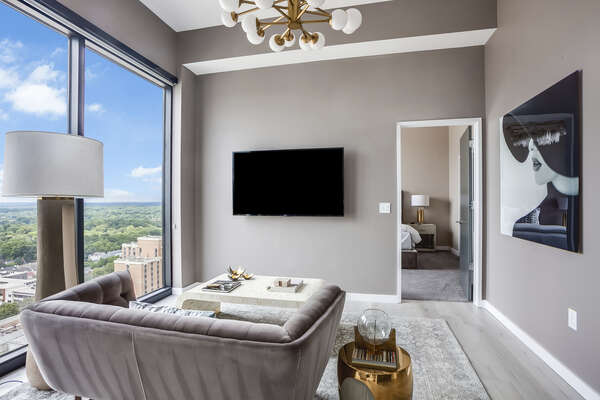 Living Area with Sofa, TV, and Large Window with City View