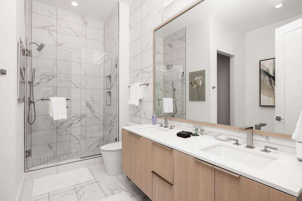 An en-suite bathroom featuring a double vanity and a spacious walk-in shower and a tub