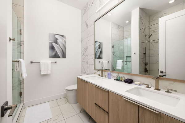 An en-suite bathroom featuring a double vanity and a spacious walk-in shower and a tub